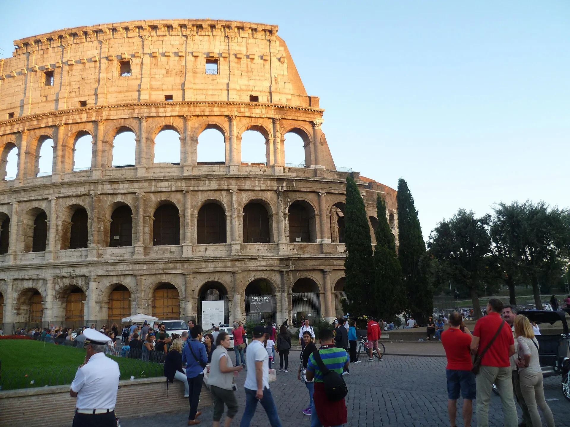 The Colosseum's stone arches with people walking past
